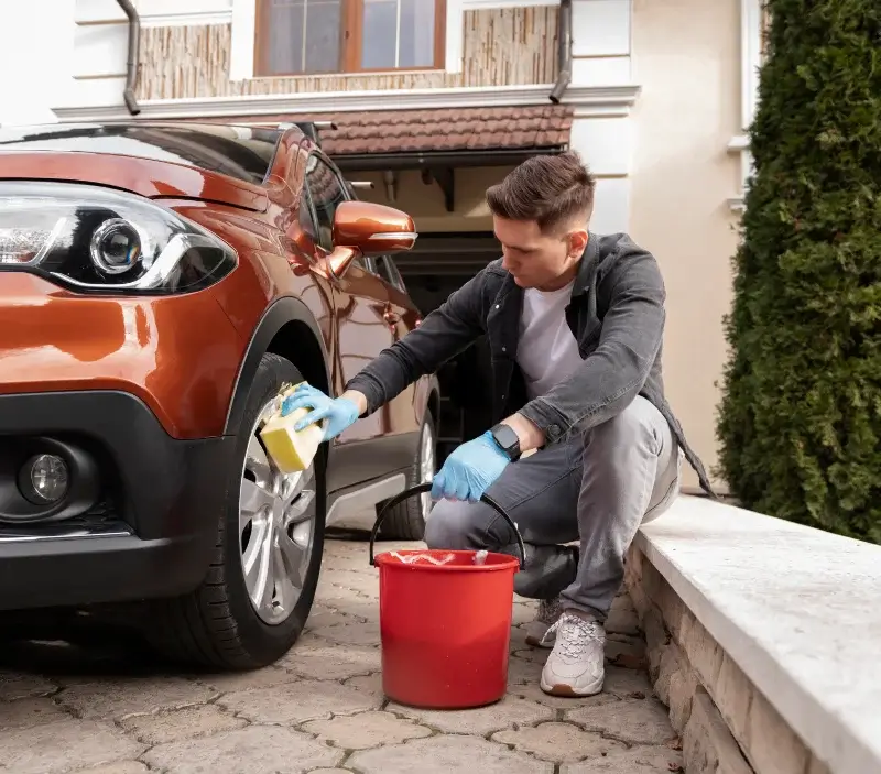 Lavage auto à domicile Saint-Laurent-des-Hommes : professionnel intervenant sur un véhicule